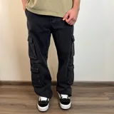 Pantalón jean cargo negro con corte holgado y múltiples bolsillos.