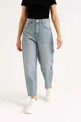 Pantalón jean color azul claro, de corte barrel, tiro medio y detalle de presilla en el lateral de la pierna.