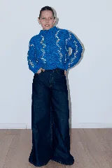 Sweater tejido a mano con lana merino color negro y bordado con lana color crudo. Es corto, a la cintura y de cuello alto.