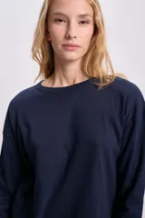 Remera de manga larga azul marino con cuello redondo y corte recto.