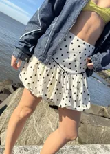 Falda mini balloon color crudo con estampado de lunares negros y cintura alta.
