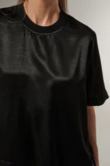Blusa negra de poliéster con cuello redondo y corte ancho.