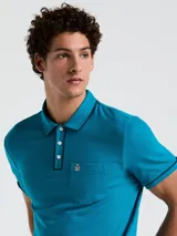 Polo azul con cuello tipo camisero, mangas cortas con ribete en contraste y bolsillo de parche en el pecho.