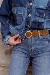 Cinturón negro de cuero con hebilla circular dorada.