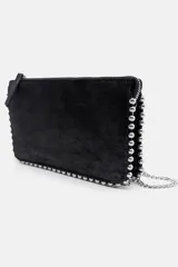 Bolso bandolera negro con tachas plateadas en los bordes. Tiene cierre de cremallera y asa de cadena extraíble.