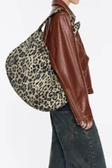 Bolso shopper de nylon con estampado animal print en tonos verde y negro. Tiene doble asa de mano, asa de tejido, bolsillo interior y etiqueta cerillera.