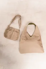 Bolso hobo reversible color azul marino, con textura símil cuero y correa bandolera extraíble.