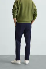 Pantalón largo de vestir gris claro con estampado de cuadros, corte slim fit y cintura elástica. Confeccionado en tejido con alta elasticidad, bolsillos frontales y cierre frontal con cremallera y botón.