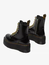 Botas de cuero negro con plataforma gruesa, cordones redondos amarillos y ojales metálicos.