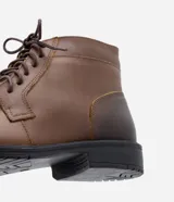 Bota de cuero marrón con caña corta, cierre de cordón y suela negra.