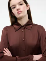 Camisa negra de viscosa con botones frontales y mangas largas.