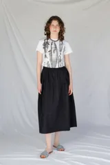 Remera blanca de algodón con cuello redondo y estampado de peces en escala de grises.