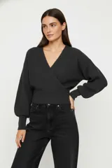 Sweater negro de acrílico con cuello en V, diseño cruzado y mangas largas abullonadas con puños ajustados.