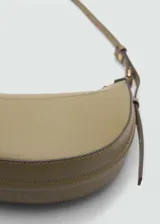 Bolso tipo hobo color verde oliva, con asa corta y correa ajustable. Cierre superior con cremallera y forro interior.
