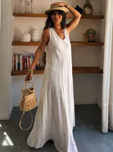 Vestido largo blanco, tipo solera, con escote en V y corte amplio y fluido.