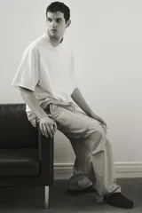 Pantalón cargo de algodón color beige, de corte holgado y tiro medio. Presenta cintura elástica con cordón ajustable, bolsillos laterales y grandes bolsillos cargo con solapa en las piernas. Los bajos son ajustables con cordón oculto.