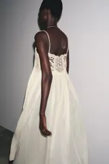 Vestido largo color crudo, de algodón, con tirantes finos y escote recto. Presenta detalle de crochet en la parte superior.