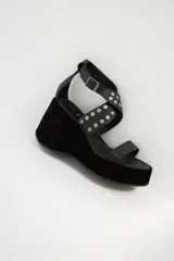 Sandalias negras con plataforma y taco de cuña, tiras de cuero con apliques de tachas plateadas y hebilla lateral.