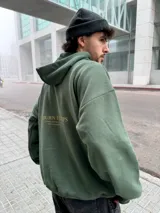 Hoodie verde militar de felpa con frisa gruesa, corte boxy, estampado dorado en la espalda con la frase "BURN THE SHIPS" y terminaciones de calidad superior.