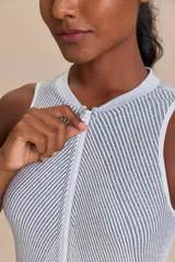 Enterito corto color salmón, de tejido de punto sin costuras, con cierre frontal y espalda descubierta.