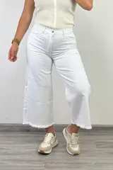 Pantalón jean blanco de corte culotte, con tiro alto, pierna ancha y terminación desflecada.
