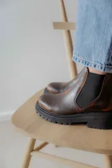 Bota Chelsea de cuero negro con elástico lateral y suela track.