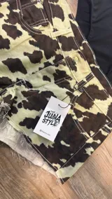 Short de jean con estampado animal print de vaca en blanco y negro, tiro alto, corte ajustado y ruedo desflecado.