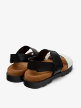Sandalias con plataforma de cuero vacuno, con dos tiras anchas, una negra y otra blanca, con ajuste de velcro.