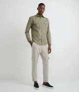 Camisa verde militar de manga larga en sarga de algodón, con cuello clásico, cierre frontal abotonado y dos bolsillos con solapa abotonada en el pecho.