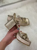 Sandalias de fiesta color champagne con plataforma y taco cuadrado, tiras cruzadas en el empeine y pulsera al tobillo con hebilla.