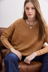 Sweater color ocre con diseño floral en jacquard y lurex a tono, escote redondo y mangas largas.