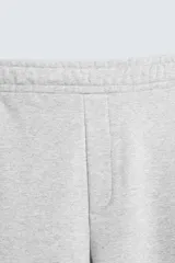 Pantalón jogger wide fit negro confeccionado en tejido de algodón con interior rizo. Pernera ancha, cintura elástica ajustable con cordón interior, bolsillos laterales y bolsillo trasero de plastrón.