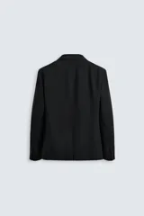 Blazer negro de lana con cuello de solapa de muesca, corte recto, manga larga con puños abotonados, bolsillos de vivo en el pecho y de solapa en la cadera, abertura en la parte posterior y cierre frontal con botones. Colección Origins.