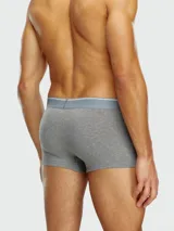 Pack de tres bóxers Diesel, uno gris liso con pretina gris claro con logo, y dos con estampados.