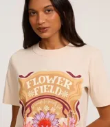 Remera color crema de algodón con estampa floral, cuello redondo y manga corta.