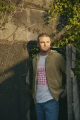 Campera con capucha color verde, de tela tipo toalla con cierre frontal y bolsillos laterales.