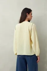 Camisa blanca a rayas grises, de lino, con cuello mao, mangas largas abullonadas y bordados en las sisas.
