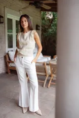 Pantalón negro de lino con corte acampanado, tiro alto y pinzas delanteras.