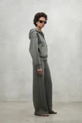 Campera gris con capucha ajustable con cordones, cierre frontal y bolsillos laterales.