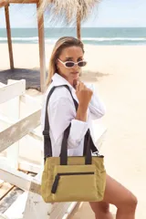 Bandolera morral color tostado con asas de mano y correa de hombro ajustables en color negro. Cuenta con un compartimento principal con cierre, un bolsillo frontal con cierre y tirador con la marca "LINCOLN'S", un bolsillo trasero con cierre y bolsillos laterales abiertos.