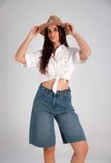 Camisa blanca de manga corta con detalles de broderie y nudo para atar en la parte delantera.