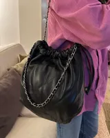 Cartera tipo bolso capitoneada de cuero color rojo, con asa de cadena plateada entrelazada con cuero. Forrada por dentro y con bolsillo interno.