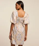 Vestido corto evasê confeccionado en tricolina con estampado abstracto de flores y líneas. Tiene escote corazón y mangas abullonadas.