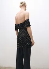 Vestido corto negro con escote strapless y detalle de strass plateados.