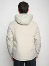 Campera corta de abrigo Umbro Crafted Pro, color negro con paneles laterales en gris. Presenta capucha con cordón ajustable, cierre frontal completo y logo de la marca bordado en el pecho.