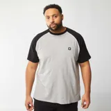 Remera gris con mangas cortas raglán negras y cuello redondo.