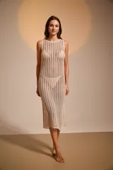 Vestido midi de acrílico color beige, tejido al crochet, con cuello redondo y tajo lateral.