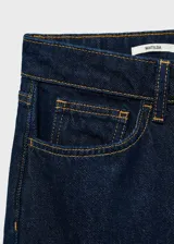 Pantalón de jean azul oscuro de corte recto, tiro medio, con cierre de cremallera y botón.