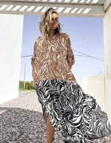 Vestido camisero largo con estampado de hojas en tonos marrones y blancos en la parte superior, y estampado de cebra en blanco y negro en la parte inferior.