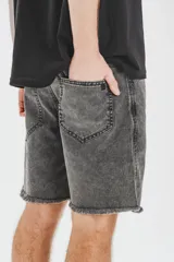 Bermuda gris con efecto lavado, de corte recto y largo a la rodilla. Presenta cintura con bragueta y botón metálico, bolsillos delanteros y traseros, y ruedo desflecado.